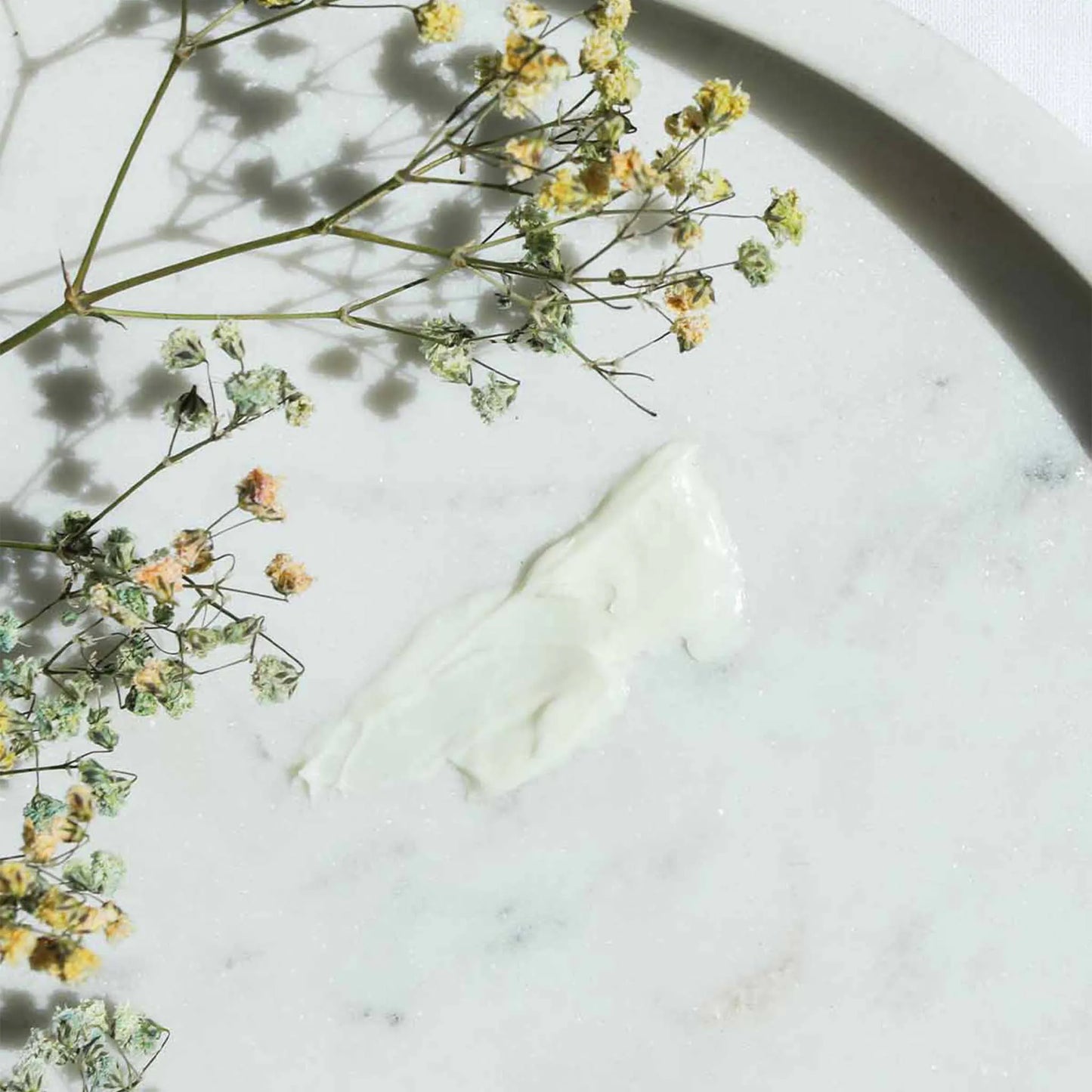 la crème est étalée sur une table et un bouquet de fleurs est posé dessus
