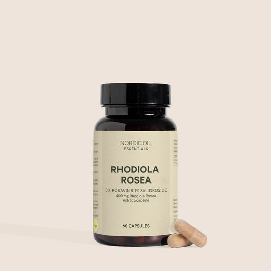 Flacon brun de compléments Rhodiola Rosea avec deux capsules à côté sur fond beige
