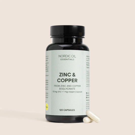 Flacon sombre de compléments Zinc et Cuivre de Nordic Oil Essentials avec deux capsules à côté.
