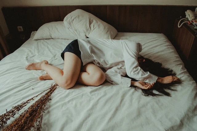 Femme souffrant allongée sur un lit