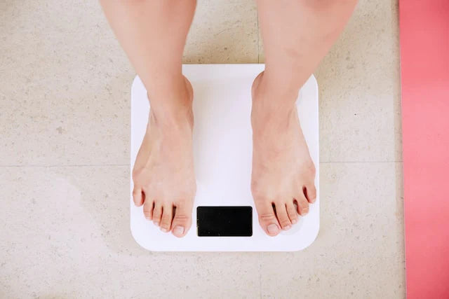 Une personne vérifiant son poids corporel avec une balance