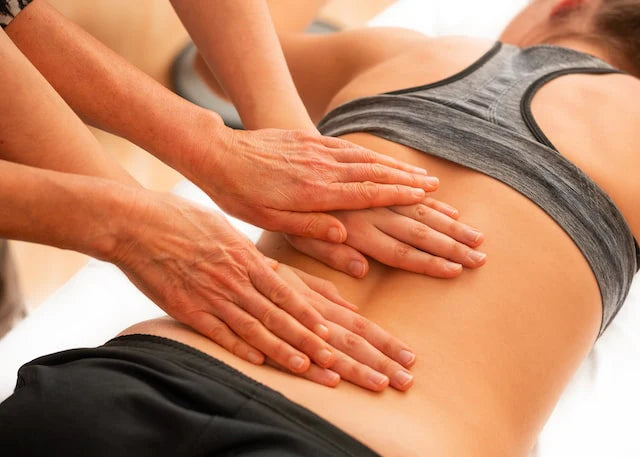 Une femme reçoit un massage du dos pour soulager sa douleur dorsale.