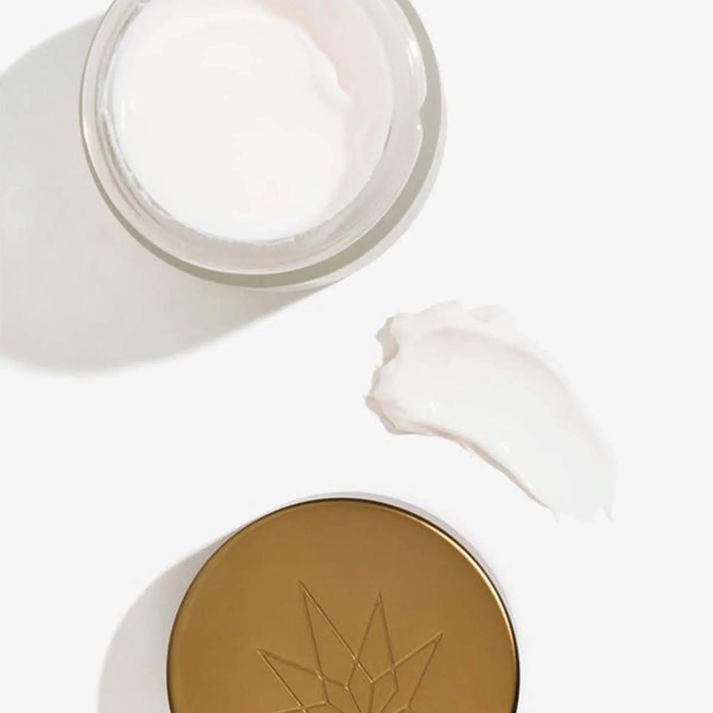 la crème a été répartie sur une table entre le produit ouvert et son couvercle