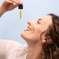 Femme souriante avec un dosar rempli d'huile de CBD de Nordic Oil