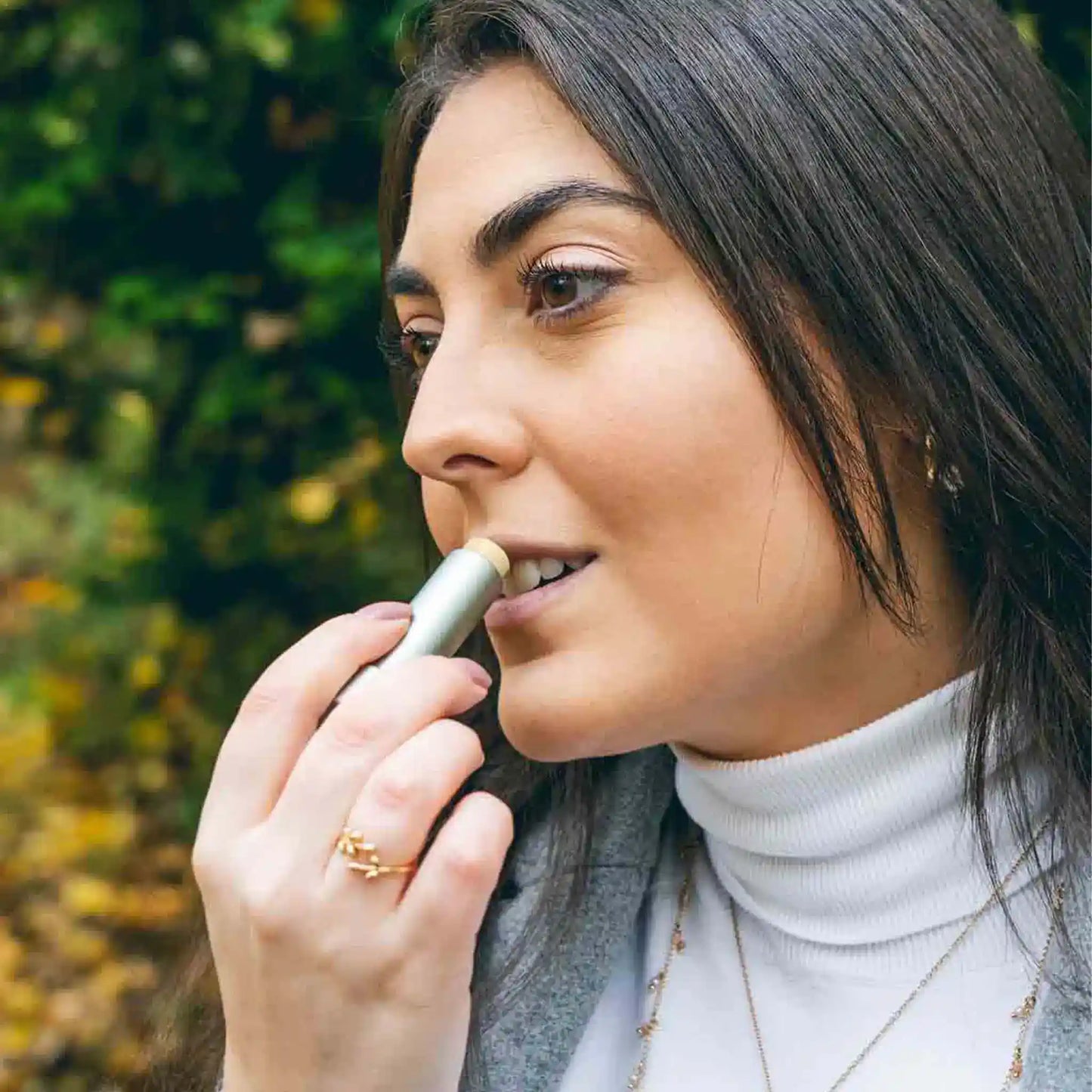 Une femme applique du baume à lèvres CBD sur ses lèvres.